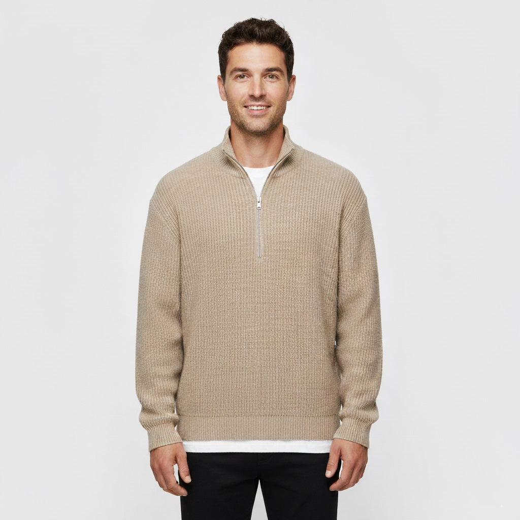 Man wearing a beige half-zip sweater on a white background